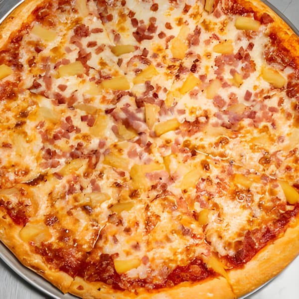 A whole Apna Pizza with pineapple and ham toppings, sliced and ready to eat.