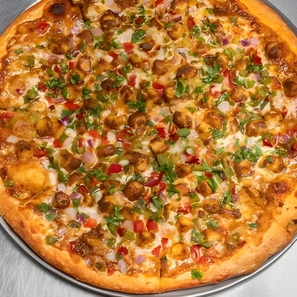 Close-up of a whole Apna Pizza with chicken, red and green peppers, and onions.