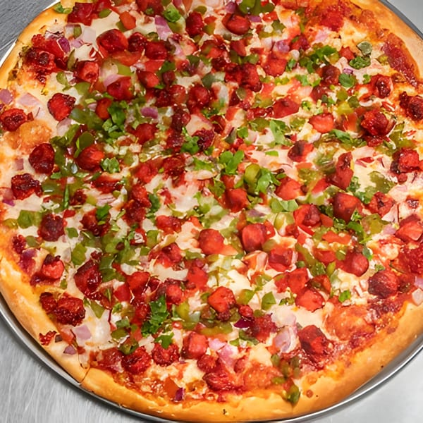 A vibrant Apna Pizza with red chicken tikka, green peppers, and white onions on a golden crust.